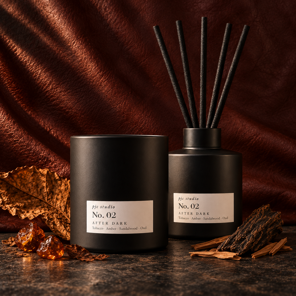 No. 02 After Dark candle standing in front of the matching reed diffuser, photographed straight on
