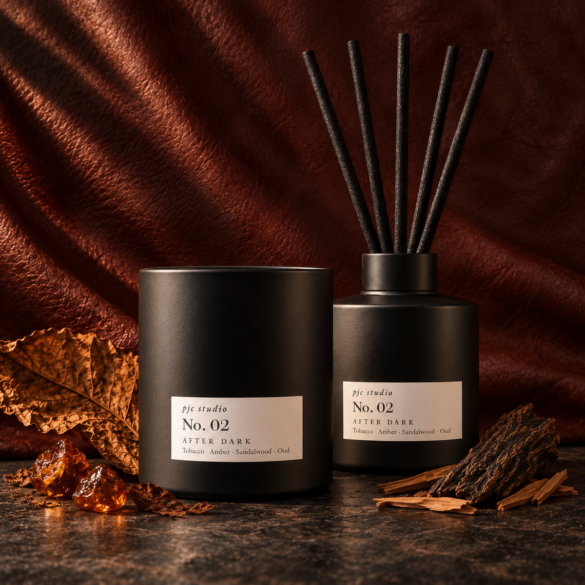 No. 02 After Dark candle standing in front of the matching reed diffuser, photographed straight on